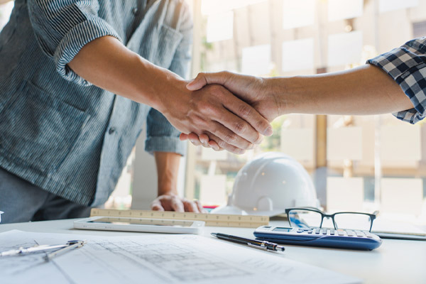 homeowner shaking hands with heating repair contractor